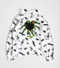 Load image into Gallery viewer, A white long-sleeve mock-neck sweatshirt featuring an all-over black spider and dragonfly print, with a large green and black spider graphic on the chest.
